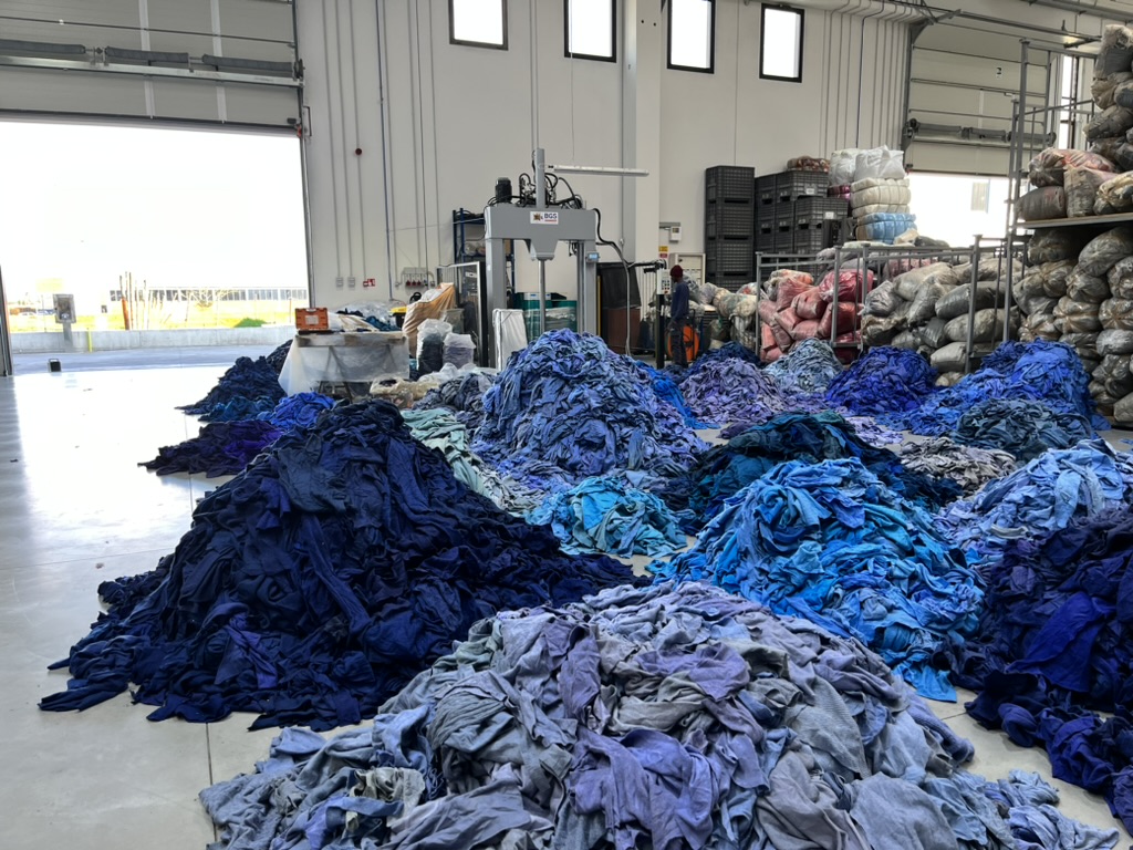 Heaps of blue clothes, sorted for shredding into upcycled materials.